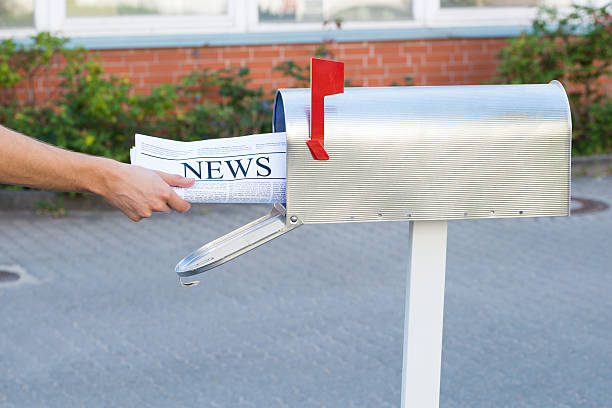 istock Person Hands Opening Mailbox To Remove Newspaper 506163490