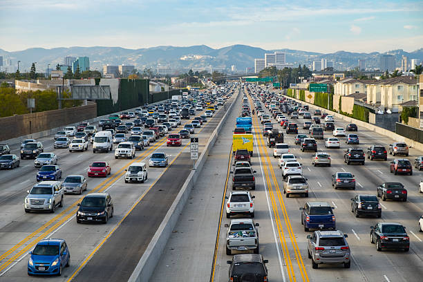 Friday Traffic on the 405 freeway North Los Angeles California Los Angeles, CA, USA - January 22th, 2016: A northbound view of the 405 freeway during Friday afternoon traffic with Getty Museum, Westwood and Santa Monica mountains in the background.   los angeles traffic jam stock pictures, royalty-free photos & images