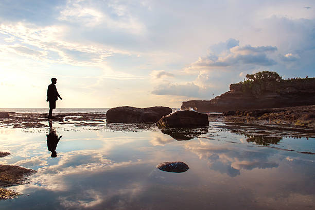 istock Silhouette a man walking with reflection on the water 506163778
