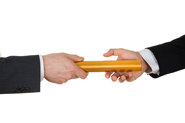 istock Two Hands Passing A Golden Relay Baton 506163812
