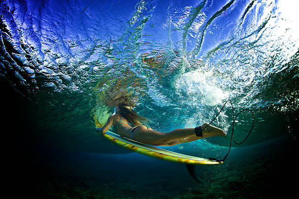 istock Beautiful girl in a bikini duckdives a wave 506165514