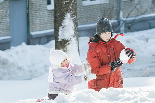 deux enfants jouant avec des jouets en plastique outil de jour neigeux - fitness trainer photos et images de collection