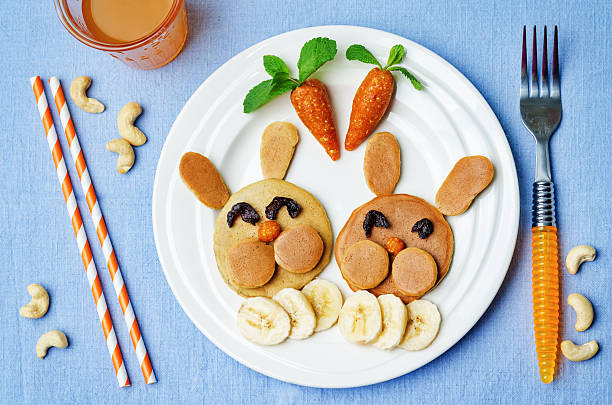 Pancake in the form of a rabbit for children Pancake in the form of a rabbit and dried apricots cashew carrots for breakfast for children for Easter. toning. selective Focus bunny pancake stock pictures, royalty-free photos & images