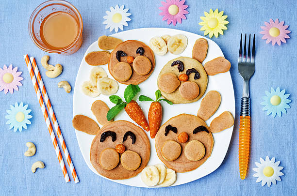 Pancake in the form of a rabbit for children for Easter Pancake in the form of a rabbit and dried apricots cashew carrots for breakfast for children for Easter. toning. selective Focus bunny pancake stock pictures, royalty-free photos & images