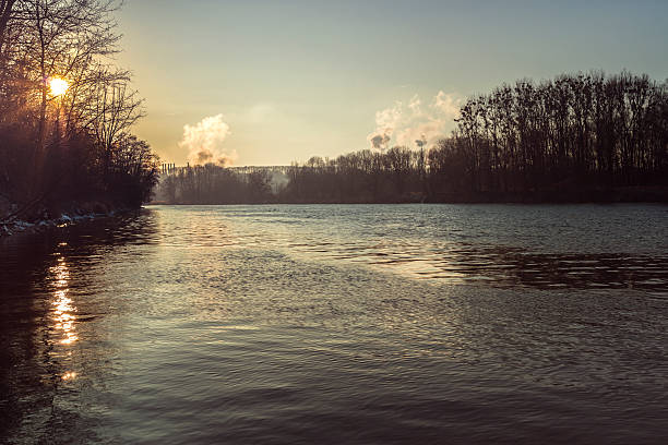 river scene in winter without snow. smoking industry pipes in the background