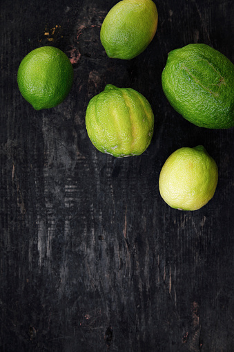 Fresh limes on dark wooden table
