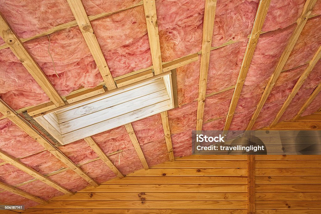 Fiberglass Roof Insulation Fiberglass insulation installed in the sloping ceiling of a timber house. Insulation Stock Photo