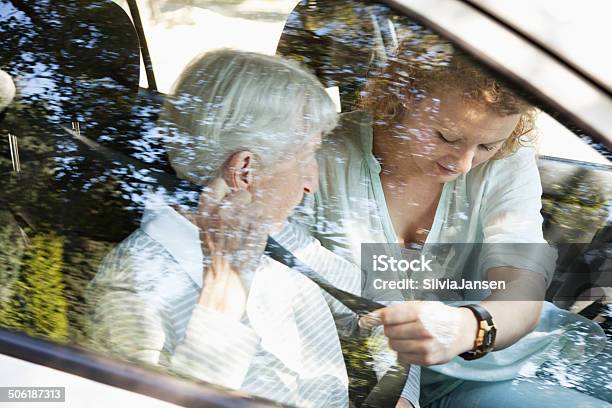 Senior And Young Woman Fastening Seat Belt For Safety Stock Photo - Download Image Now