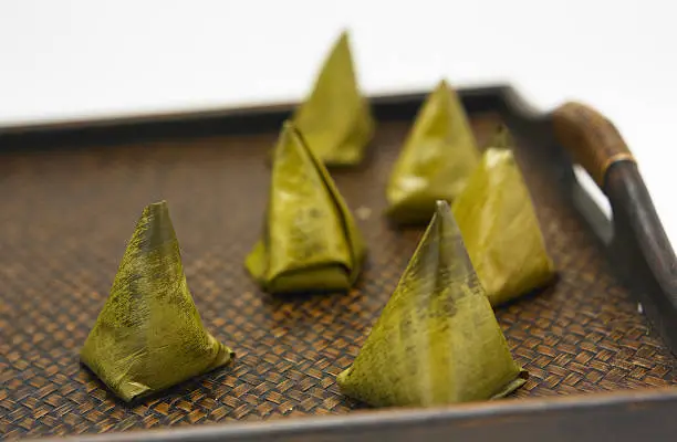 Thai traditional sticky rice dessert in banana leaf packaging.