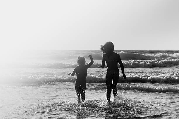 two happy kids playing on the beach at sunset