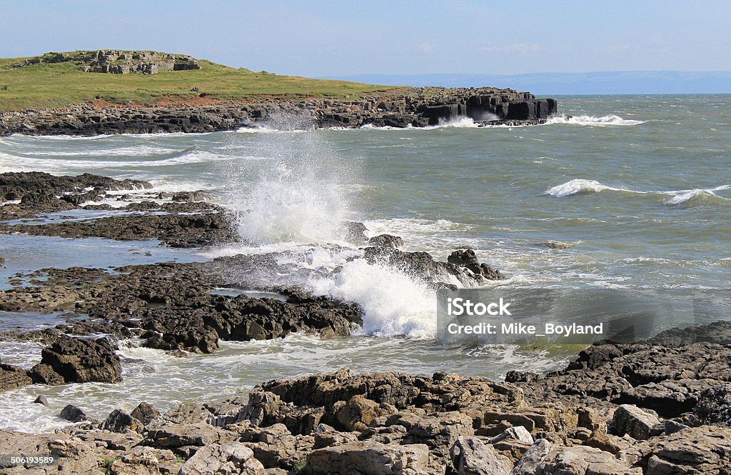 Waves crashing on rocks Waves crashing on rocks in Rest Bay, South Wales Beach Stock Photo