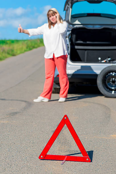 istock female driver on the road asking for help 506193868