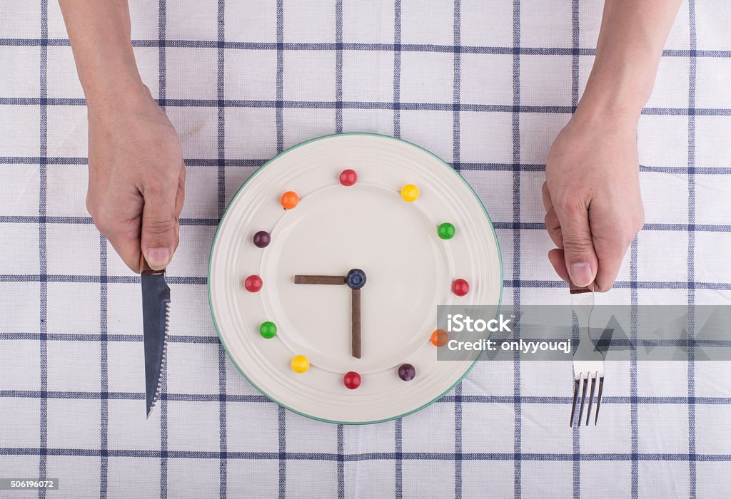 Lunch time concept, clock in plate, knife and fork Banquet Stock Photo