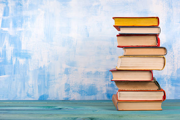 istock Stack of colorful hardback books, open book on blue background 506196802