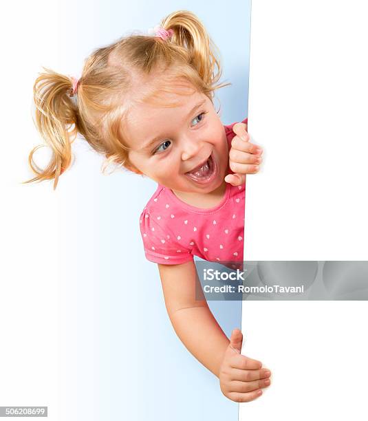 Smiling Little Girl Looking Behind A White Board Stock Photo - Download Image Now - Child, Excitement, White Background