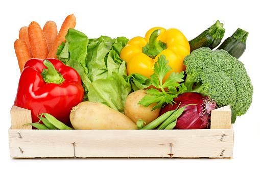 fresh vegetables in a wooden box isolated on white