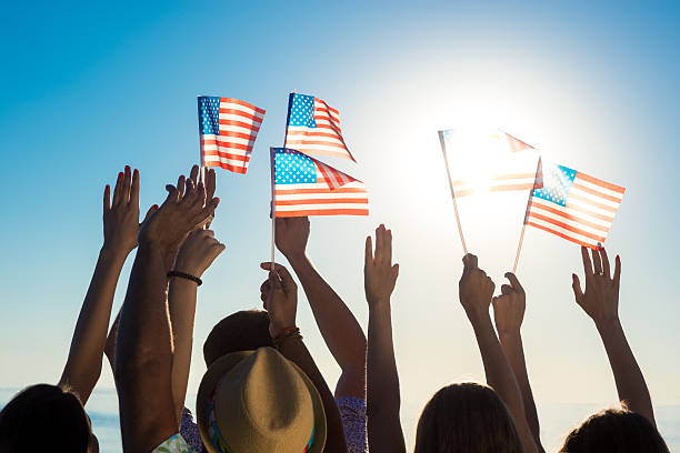 istock Young people waving American flags at sunset. 506215408