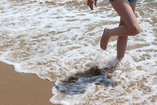 mädchen paddeln in wellen, beine, wasser, barfuß, seaside beach - human foot wading sea human toe stock-fotos und bilder