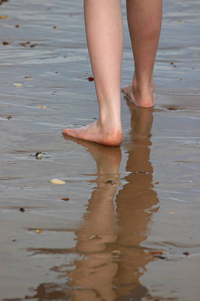 mädchen zu fuß auf wet beach und reflections im sand und meer - human foot wading sea human toe stock-fotos und bilder