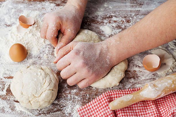 istock Baker chef prepares or kneading dough for bread or pizza 506217124