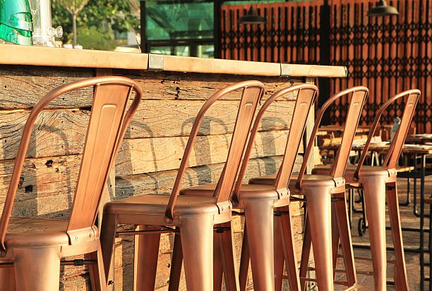 Lined up of metal bar stools Lined up of metal bar stools bar exterior stock pictures, royalty-free photos & images