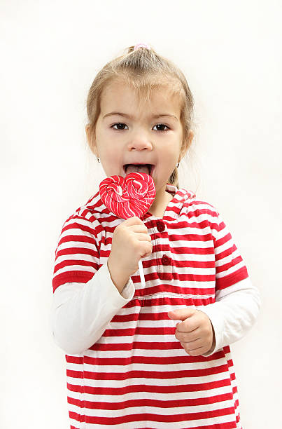 a alegre menina com pirulito - child valentines day candy eating - fotografias e filmes do acervo
