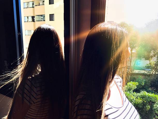 Girl at the window looking the sun January 2, Brazil - Girl at the window looking the sun feme stock pictures, royalty-free photos & images