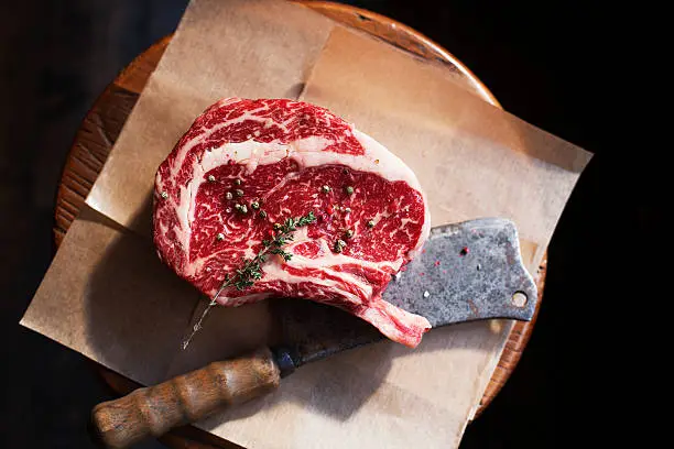 Photo of Bone In Rib Eye row Steak and knife