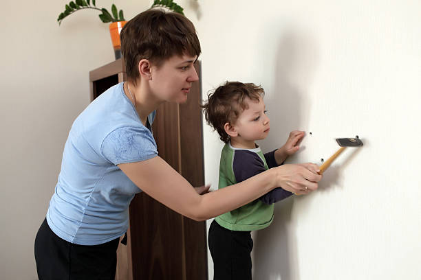 istock Mother and son hammering plastic anchor 506239186