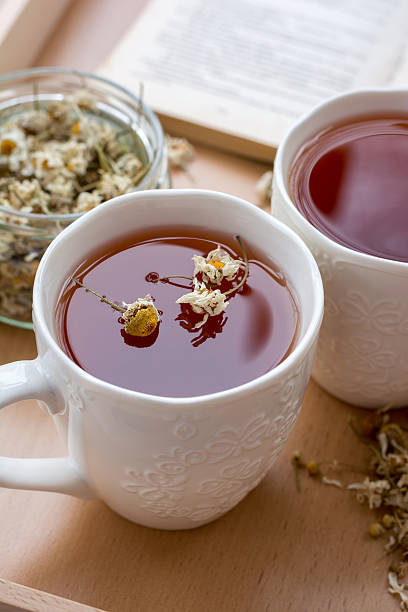 istock Herbal chamomile tea in ceramic cups on wooden tray 506239394