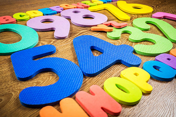 istock plastic numbers and letters on wooden background 506240760
