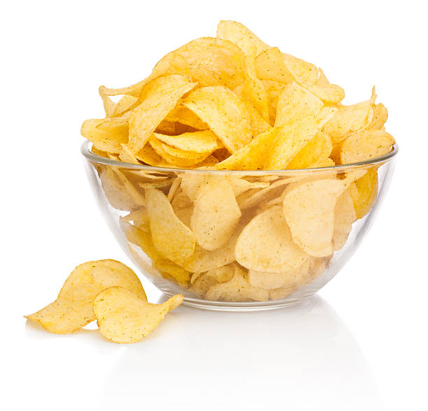 Potato chips in glass bowl isolated on white background Potato chips in glass bowl isolated on white background crisps stock pictures, royalty-free photos & images