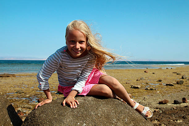 istock Little girl sitting on big stone 506241484