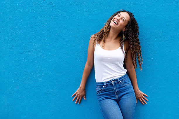 istock Cheerful young woman standing against blue wall 506243240