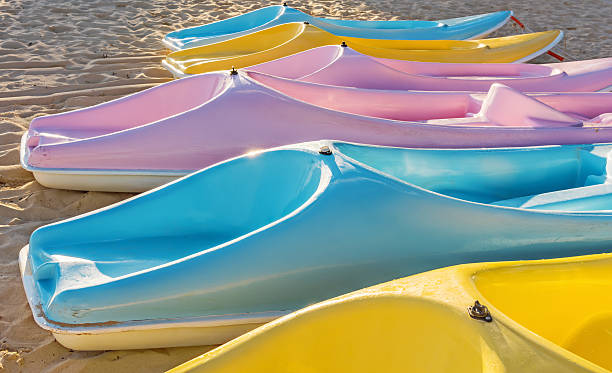 Colorful plastic anoes on sandy beach stock photo