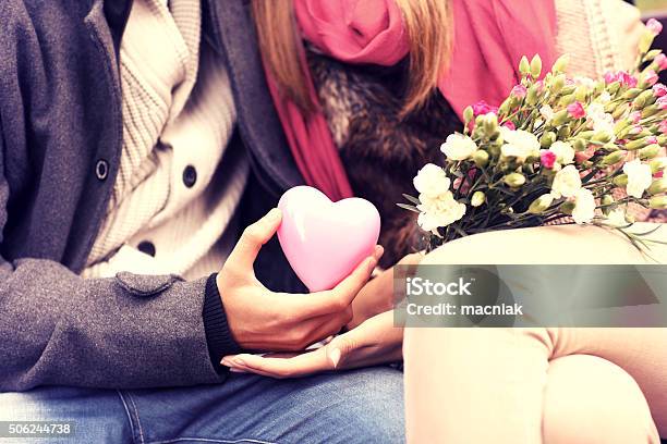 Midsection Of A Romantic Couple Sitting On Bench Stock Photo - Download Image Now - Adult, Anniversary, Autumn