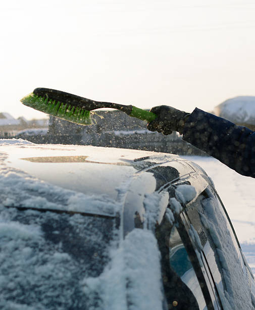 istock Young man cleans snow from car 506245284