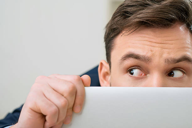 istock Pleasant office worker hiding behind laptop 506245730