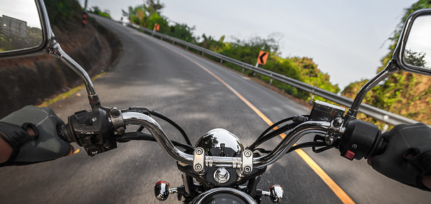 Man riding the motorcycle on the empty asphalt road