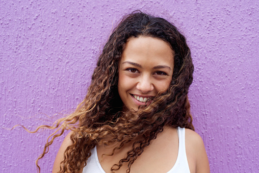 Closeup portrait of beautiful young woman smiling with curly hair