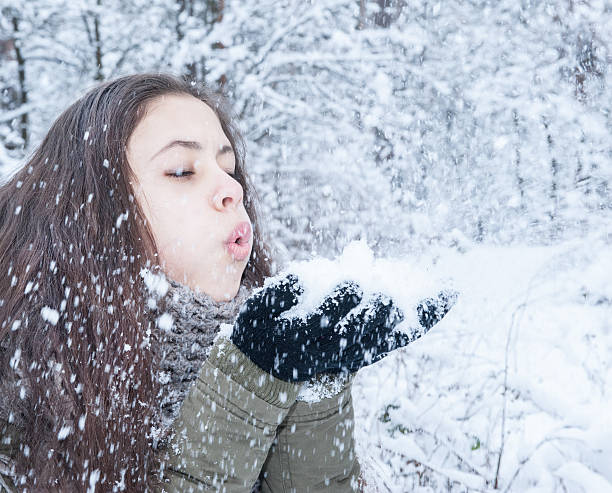 istock Girl blowing on the snow 506247258