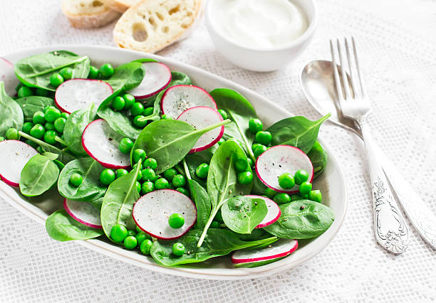 istock Green peas, radish and baby spinach salad on ceramic plate 506247456