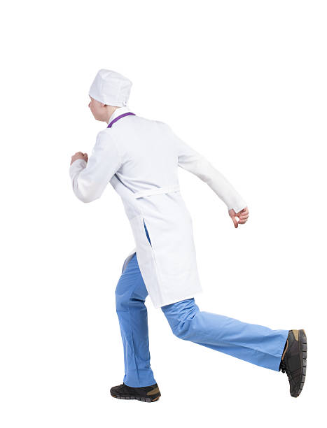 istock Back view of running doctor in a robe 506251134