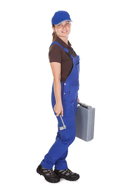 Happy young female technician holding toolkit on white background