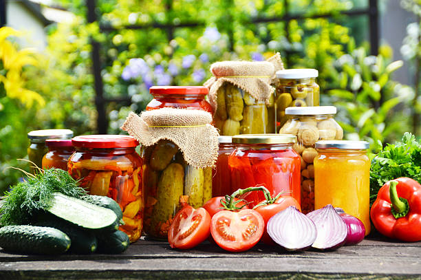 frascos de salmuera verduras en el jardín.  marinado de alimentos - alimento conservado fotografías e imágenes de stock