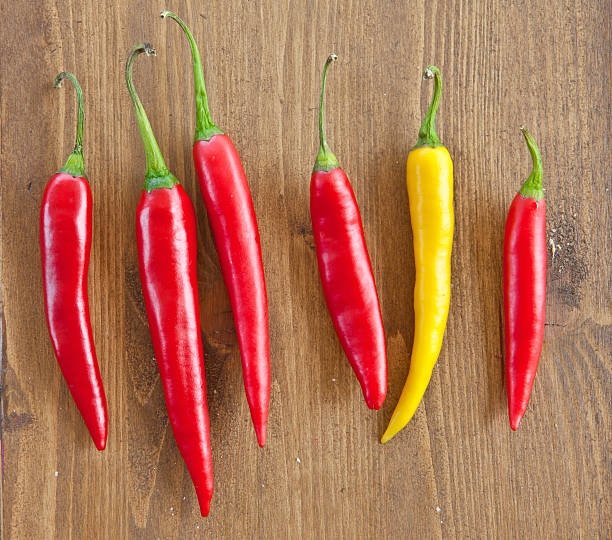 istock Fresh chili peppers on wooden background 506284339
