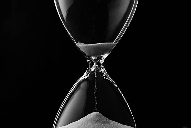 istock Sand trickling through the bulbs of an hourglass 506286027