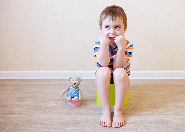 potty training toddler and teddy child sitting on the pot in the company of his beloved teddy bear toy nail biting stock pictures, royalty-free photos & images