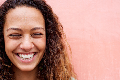 Close up portrait of laughing young woman with curly hair