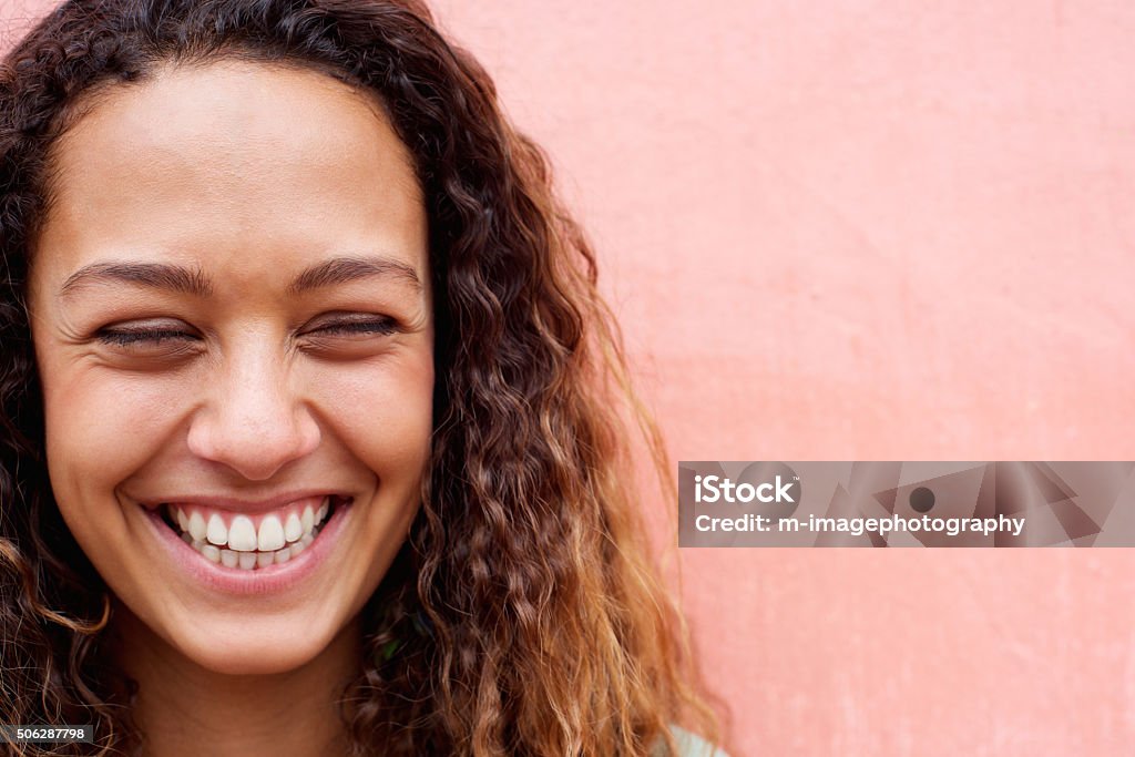 Cheerful young woman laughing Close up portrait of laughing young woman with curly hair Close-up Stock Photo